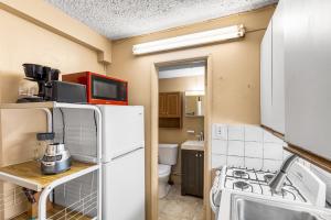 a small kitchen with a refrigerator and a sink at Caribbean home with a view condo in Christiansted