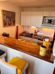 a kitchen with a wooden counter top in a kitchen at Petit nid cosy au cœur du Puy 1 à 5 personnes in Le Puy en Velay