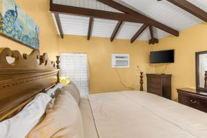 a bedroom with a bed and a flat screen tv at A getaway from your getaway condo in Christiansted
