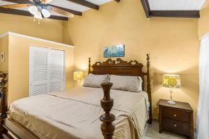a bedroom with a bed and a ceiling fan at A getaway from your getaway condo in Christiansted +11 photos