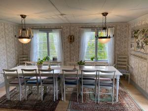 uma sala de jantar com uma mesa branca e cadeiras em Handlarens villa - Vandrarhem de luxe em Söderbärke