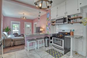 a kitchen with pink walls and a stove top oven at Colorado Columbine Cottage in Colorado Springs
