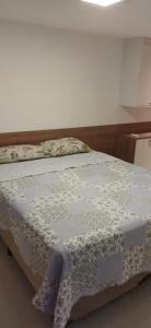 a bedroom with a bed with a quilt on it at Praia Itacimirim Summer Ville 19D in Itacimirim