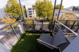 a balcony with two chairs and a table on top at Come4Stay Passau - Wohnung Guby - 2 Zimmer I bis zu 4 Gäste in Passau