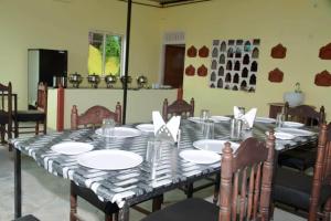 una mesa de comedor con platos y servilletas. en The Jungle Camp Ranthambore, en Khilchīpur