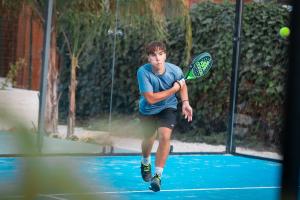 un joven balanceando una raqueta de tenis en una pelota de tenis en B&B Villa Anna, en Marinella di Selinunte