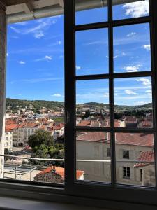 una ventana con vistas a la ciudad desde un edificio en Petit nid cosy au cœur du Puy 1 à 5 personnes en Le Puy-en-Velay