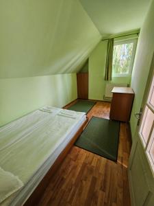 um pequeno quarto com uma cama e uma janela em Fűzfa Apartman em Joseni