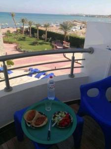 a table with a plate of food on a balcony at Chalet front the beach in Hurghada