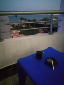a blue table in front of a window with a view at Chalet front the beach in Hurghada