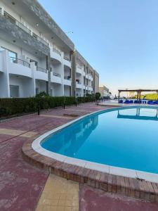 una gran piscina frente a un edificio en Chalet front the beach en Hurghada