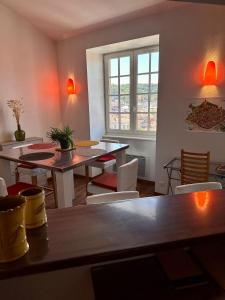 un comedor con mesas y sillas y una ventana en Petit nid cosy au cœur du Puy 1 à 5 personnes en Le Puy-en-Velay