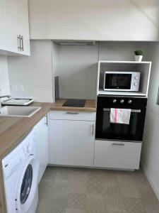 uma cozinha com um fogão e uma máquina de lavar roupa em Le Tendance Patte d'Oie - Lumineux T3 - 4 à 6 Pers em Toulouse