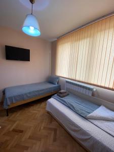 Luxury Apartment near Varna, located in Targovishte في تارغوفيشته: غرفة بسريرين وتلفزيون بشاشة مسطحة