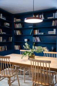 Resort po.spolu في Mokrovraty: غرفة طعام بجدران زرقاء وطاولة وكراسي خشبية
