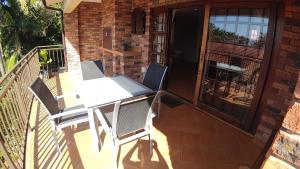 a patio with a table and chairs on a balcony at The Lagoon Flat, 53 Nkwazi Drive in Zinkwazi Beach
