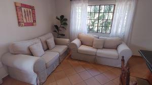 a living room with two white couches and a table at The Lagoon Flat, 53 Nkwazi Drive in Zinkwazi Beach
