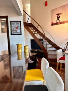 a dining room with a glass table and a staircase at Petit nid cosy au cœur du Puy 1 à 5 personnes in Le Puy en Velay