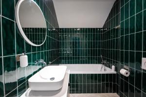 Resort po.spolu في Mokrovraty: حمام ذو بلاط أخضر مع حوض استحمام ومغسلة