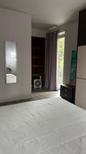 a bedroom with a white bed and a mirror at L'Alba in Magliano Alfieri