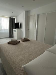 マスパロマスにあるLuxury bungalow Maspalomas Gran Canariaのベッドルーム1室(大型ベッド1台、タオル2枚付)