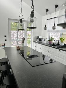 a kitchen with a black counter top and white cabinets at Sonnendeck Chalet in Großkoschen