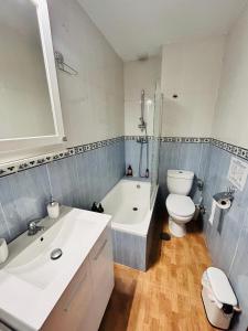 een badkamer met een wastafel, een bad en een toilet bij Nice boutique flat with terrace in Fuengirola