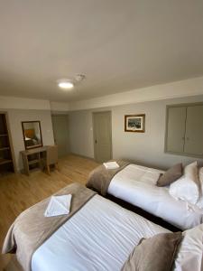 Habitación con 2 camas en una habitación con escritorio. en Gogartys Temple Bar Apartments, en Dublín