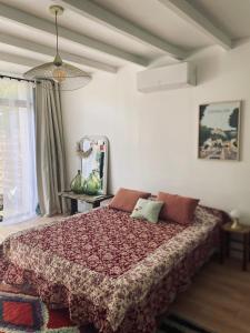 a bedroom with a large bed with a red blanket at Gîte Mas Provençal Piscine Parking Privé L'Isle-Sur-La-Sorgue in LʼIsle-sur-la-Sorgue