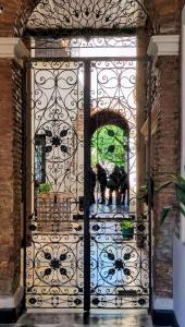an iron gate with a cow sitting inside of it at La Botica de 1852 Hotel in Chascomús