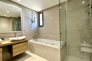 a bathroom with a tub and a sink and a shower at Marina State of Peace - Sea View in Casablanca