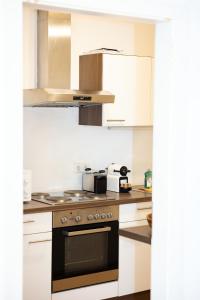 a kitchen with white cabinets and a stove top oven at Premium 80 m2 Rooftop Apartment - 5 min to Center in Vienna
