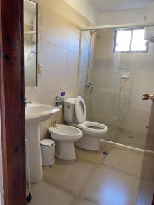 y baño con lavabo, aseo y ducha. en Medanos del Portal, en Piriápolis
