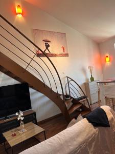 a living room with a spiral staircase and a couch at Petit nid cosy au cœur du Puy 1 à 5 personnes in Le Puy en Velay