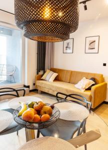 a living room with a table with a bowl of fruit at KOBIELA APARTMENTS Dębowe Tarasy in Katowice
