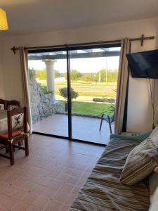 1 dormitorio con 1 cama y puerta corredera de cristal en Medanos del Portal, en Piriápolis