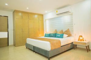 1 dormitorio con 1 cama grande con almohadas azules en Ayenda Soft Vanilla House Boutique, en Cartagena de Indias