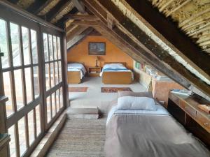 a attic bedroom with two beds and windows at El Cobijo in Chocontá