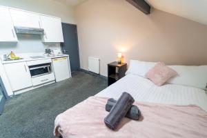 a bedroom with a bed and a kitchen with white cabinets at Remarkable 1-Bed Studio in Birmingham in Birmingham