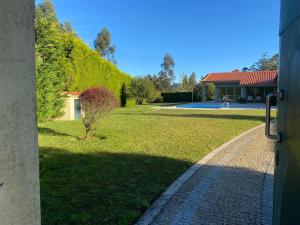 een uitzicht op een tuin met een huis bij Casa do Lago, Privacidade e Beleza Natural in Esposende