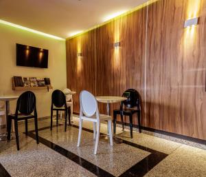 een kamer met 3 tafels en stoelen en een muur bij Hotel Villa del Mar in Mexico-Stad