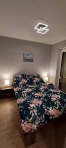 a bedroom with a bed with a floral bedspread at Apartament Jantar in Jantar