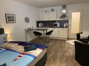1 dormitorio con 1 cama y cocina con mesa en kuebo-ferien Wohnung 3, en Kühlungsborn