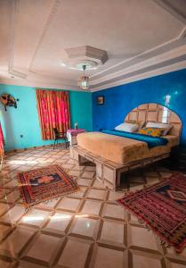 um quarto com uma cama grande e uma parede azul em The Sunrise Villa em Agadir