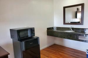 baño con TV y lavabo en Premier Inn & Suites en Oakland