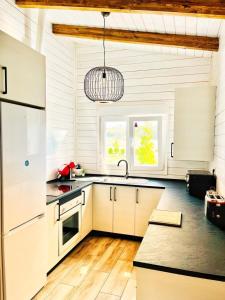 a kitchen with white cabinets and a chandelier at Eco alojamiento la Cartuja de Talamanca in Talamanca de Jarama