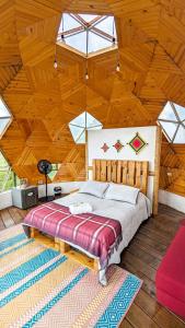 a bedroom with a large bed in a wooden ceiling at Glamping Reserva del Roble in La Vega