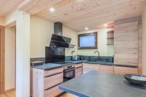 - une cuisine avec des placards en bois et un comptoir dans l'établissement Appartement Chablis - Welkeys, à Combloux