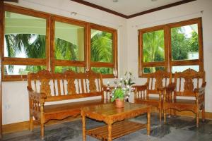 a room with wooden chairs and a table and windows at Mangrove Inn 
