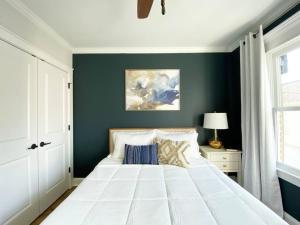 a bedroom with a white bed and a green wall at Magnolia Estate - 3 Separate Units, Courtyard in Savannah